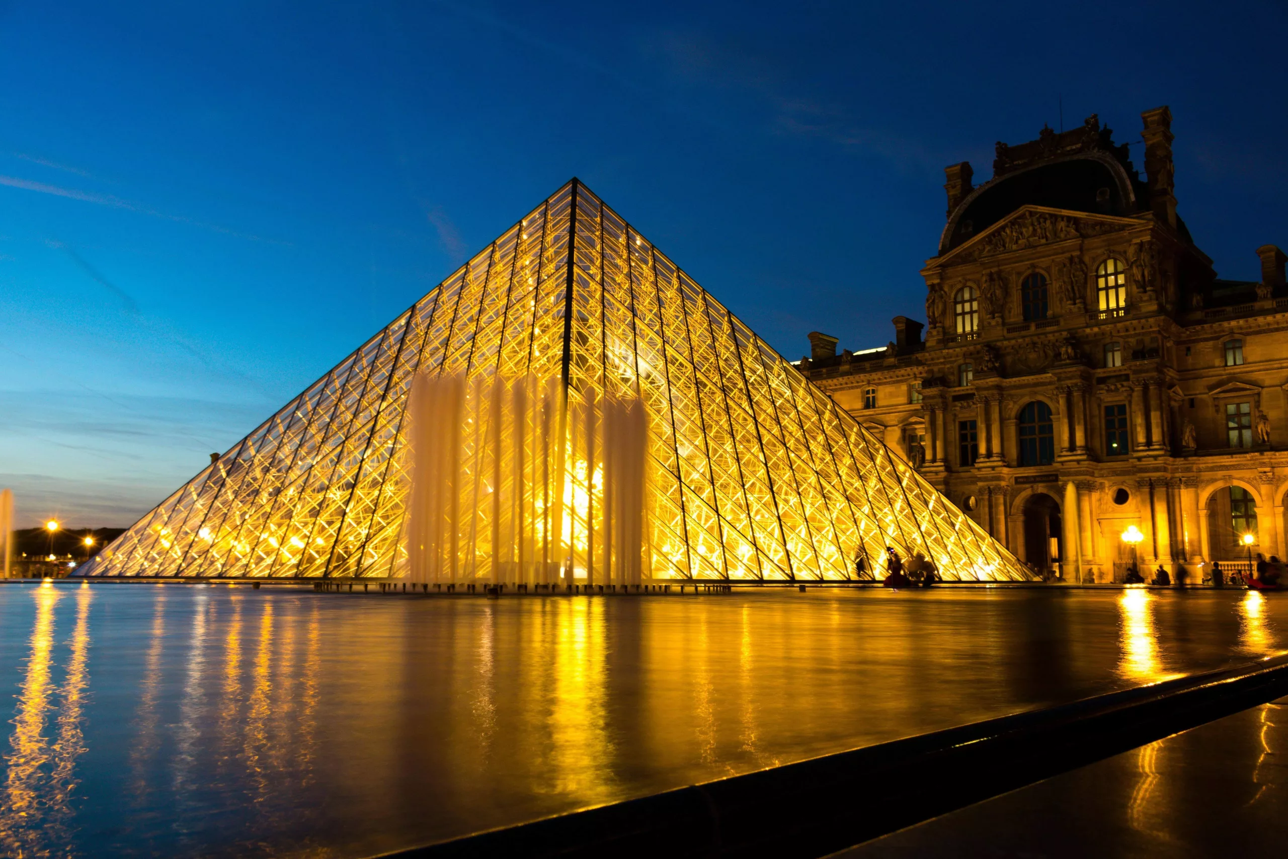 Visite privée du Louvre devant la pyramide illuminée de nuit